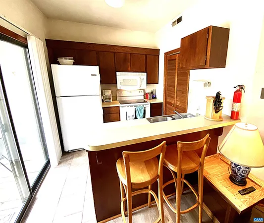 a kitchen with stainless steel appliances a refrigerator a sink a stove and white cabinets