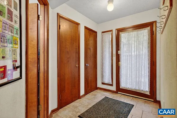 a view of a hallway with wooden floor and windows