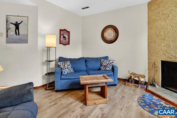a living room with furniture a rug and a wall painting