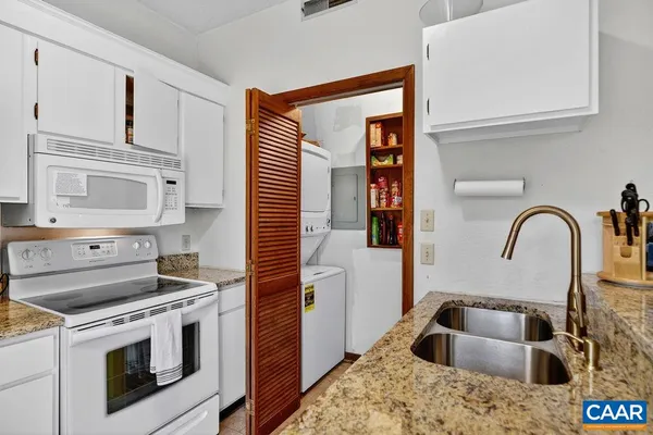 a kitchen with white cabinets and a stove top oven