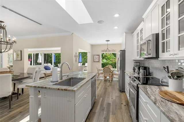 a kitchen with stainless steel appliances granite countertop sink stove and cabinets