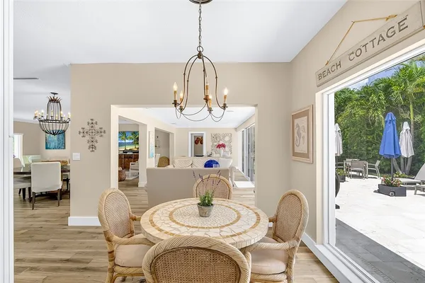a dining room with furniture a chandelier and wooden floor