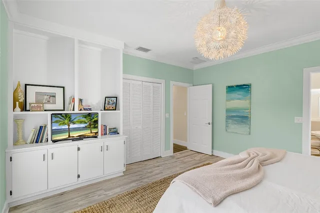 a bedroom with a bed and a chandelier