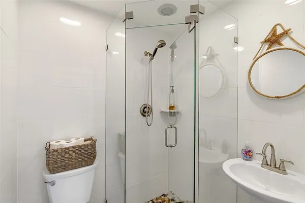a bathroom with a sink a toilet and shower
