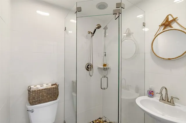 a bathroom with a sink a toilet and shower