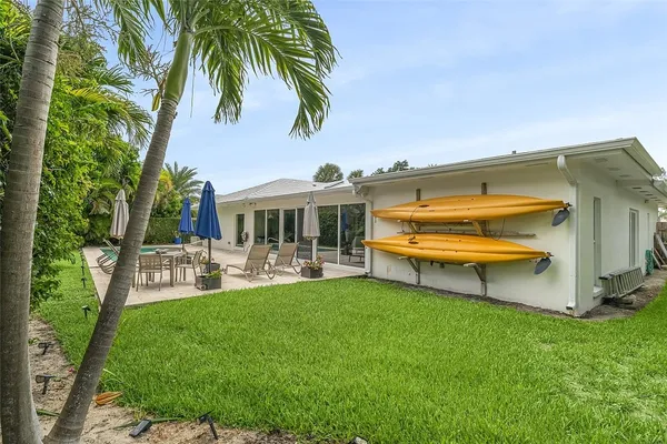 a view of a house with backyard sitting area and swimming pool