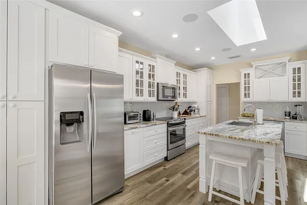 a kitchen with a refrigerator a sink a stove and cabinets