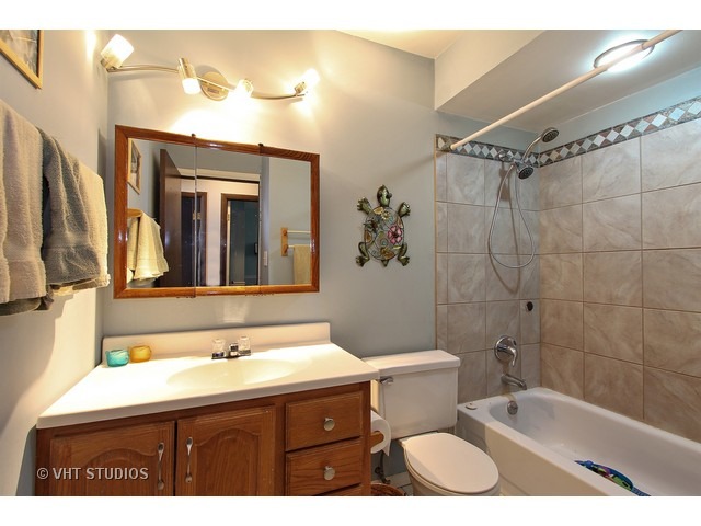 492 Rustic Drive, Unit 492 Wheeling, IL 60090 - Photo 13 of 20 a bathroom with a sink a toilet a mirror a bathtub and shower