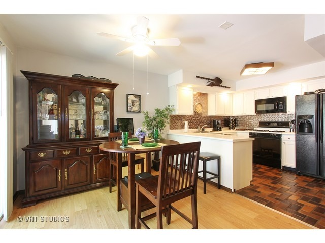 492 Rustic Drive, Unit 492 Wheeling, IL 60090 - Photo 5 of 20 a kitchen with a dining table chairs and cabinets