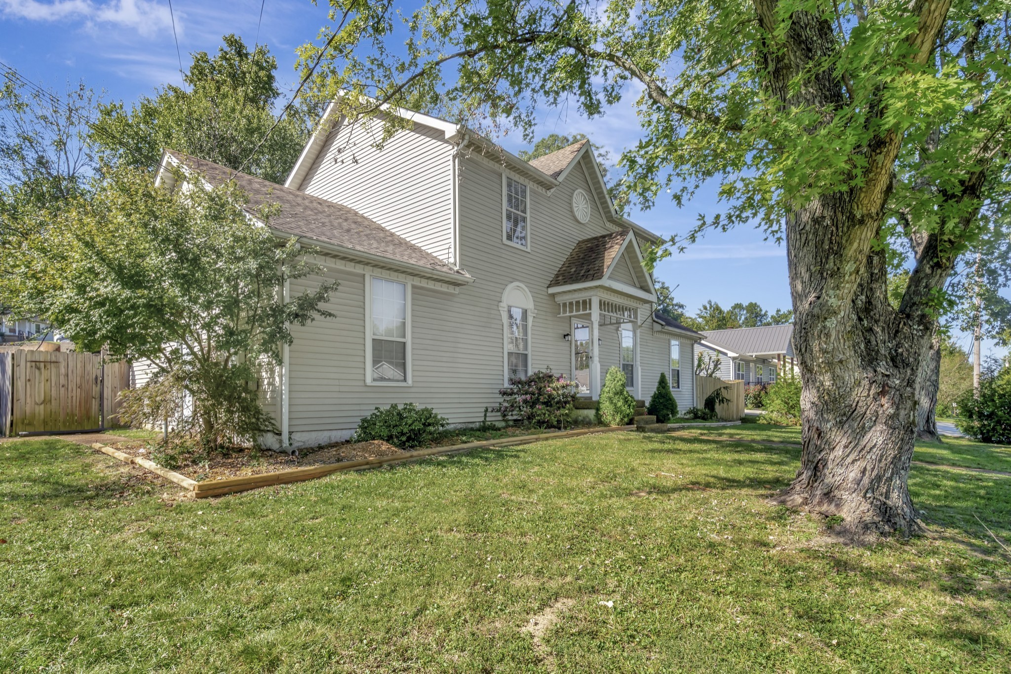1060 Jacksons Valley Road Hermitage, TN 37076 - Photo 3 of 19 a view of a white house next to a yard with a large tree