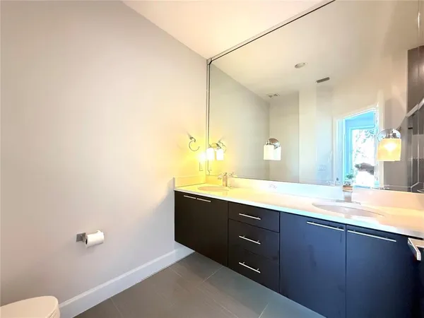 a bathroom with a granite countertop sink mirror and toilet