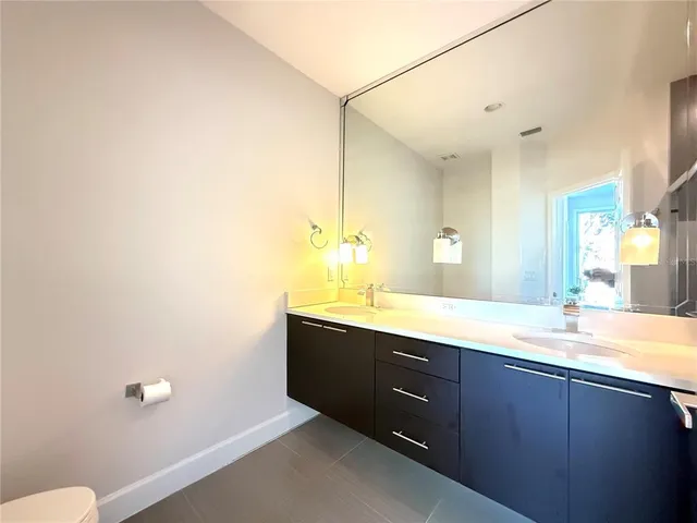 a bathroom with a granite countertop sink mirror and toilet
