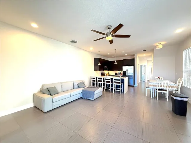 a living room with lots of furniture and kitchen view