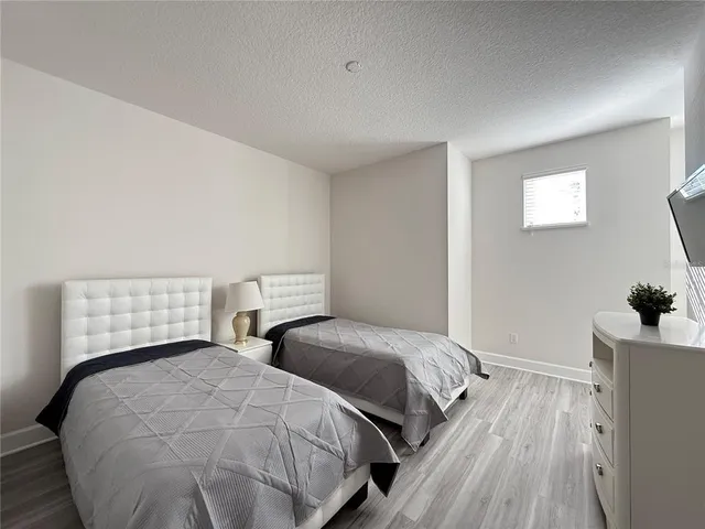 a bedroom with two beds and wooden floor