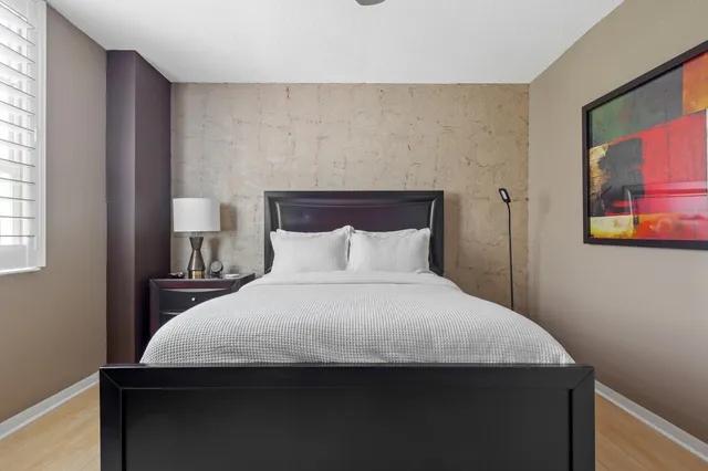 a bedroom with a bed and a painting on the wall