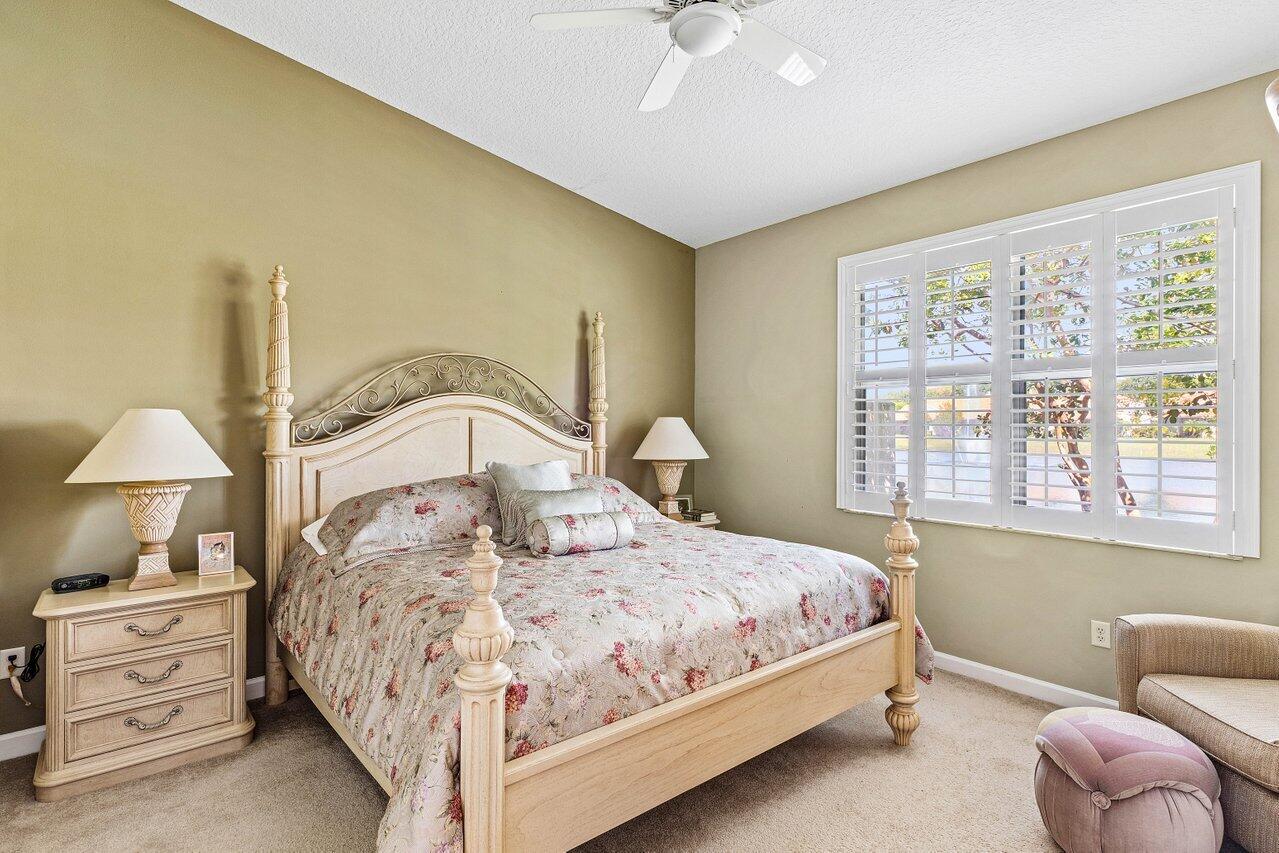 23069 Addison Lakes Circle Boca Raton, FL 33433 - Photo 12 of 26 a bedroom with a bed and a chandelier