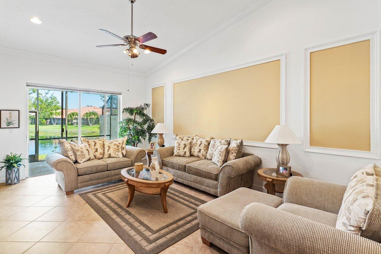 23069 Addison Lakes Circle Boca Raton, FL 33433 - Photo 10 of 26 a living room with furniture a large window and a chandelier