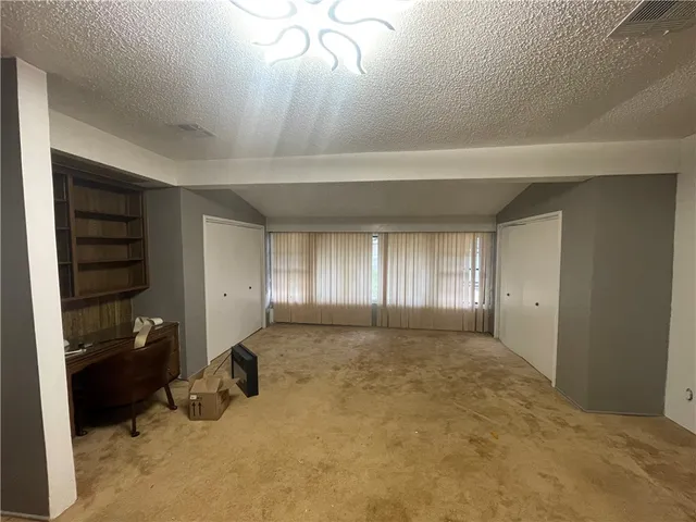a living room with furniture and a air conditioner vent