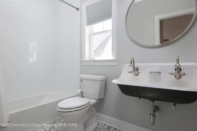 a bathroom with a sink toilet a mirror and tub