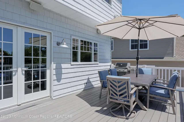 a view of a patio with table and chairs under an umbrella