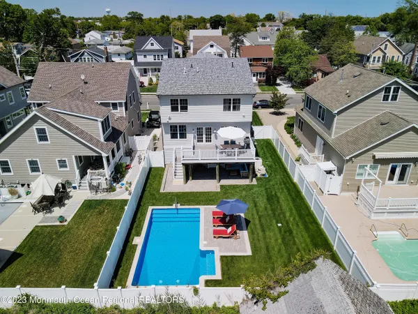an aerial view of residential houses with outdoor space and parking