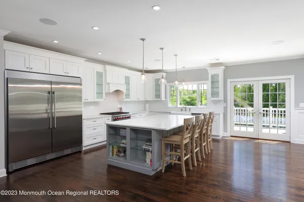 a kitchen with stainless steel appliances granite countertop a stove a refrigerator a kitchen island a stove and a wooden floors