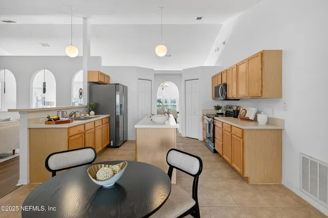 a kitchen with a dining table chairs and white cabinets