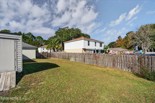 a view of a house with wooden fence next to a road
