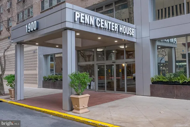 a view of a building with a potted plant and floor to ceiling windows