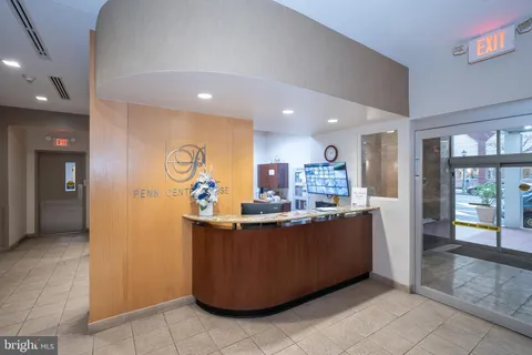 a living room with stainless steel appliances furniture a rug and a view of kitchen