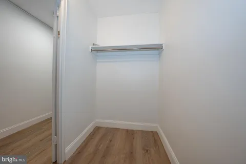 a spacious bedroom with a bed and wooden floor