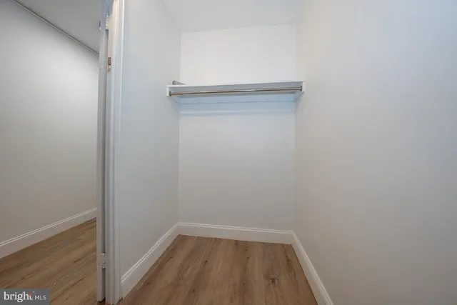 a spacious bedroom with a bed and wooden floor