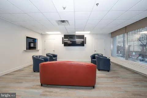 a living room with lots of furniture and view of kitchen