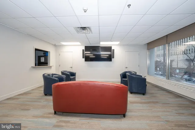 a living room with lots of furniture and view of kitchen