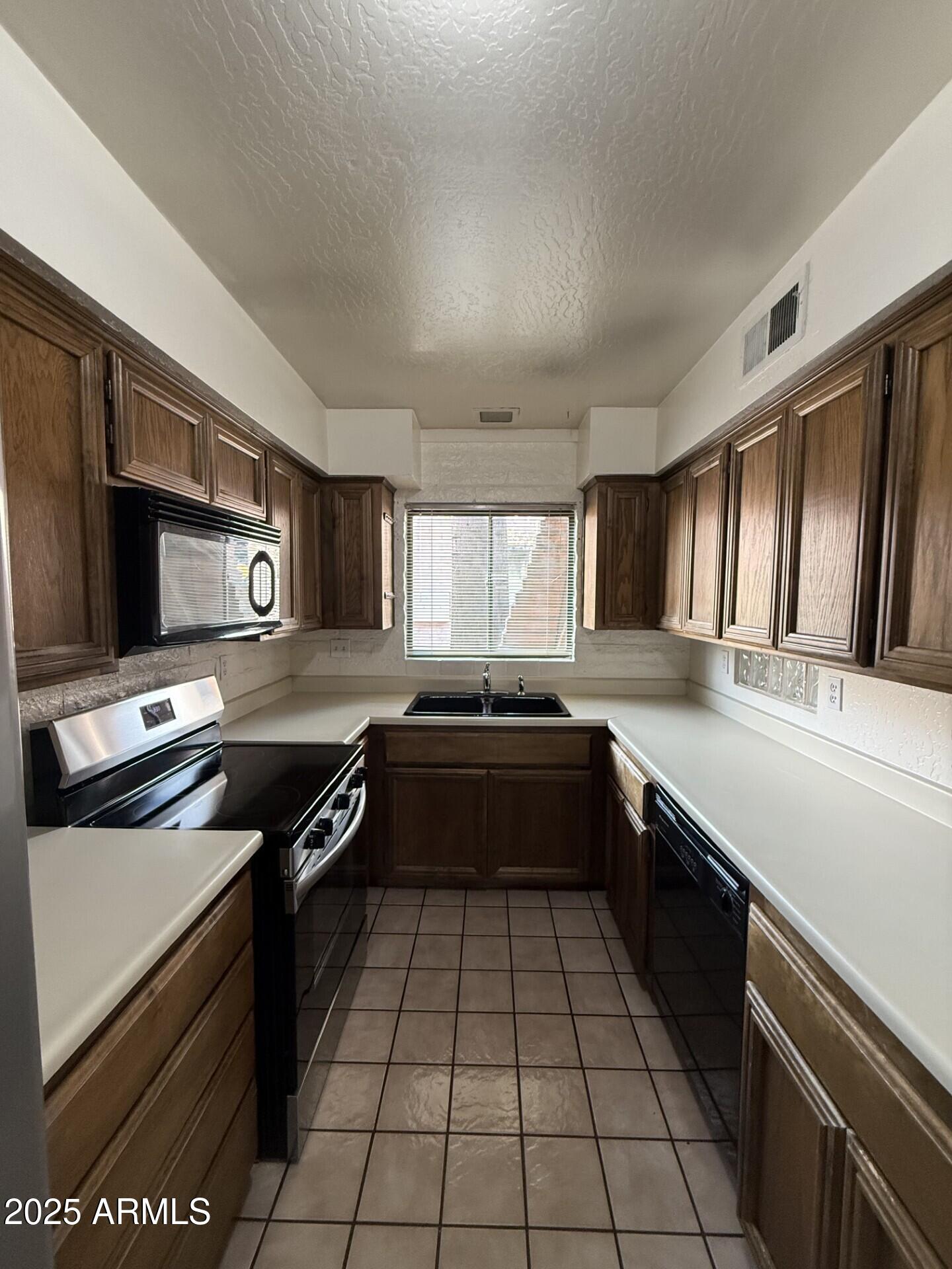 4414 East Hubbell Street, Unit 69 Phoenix, AZ 85008 - Photo 6 of 10 a kitchen with a sink stainless steel appliances and cabinets