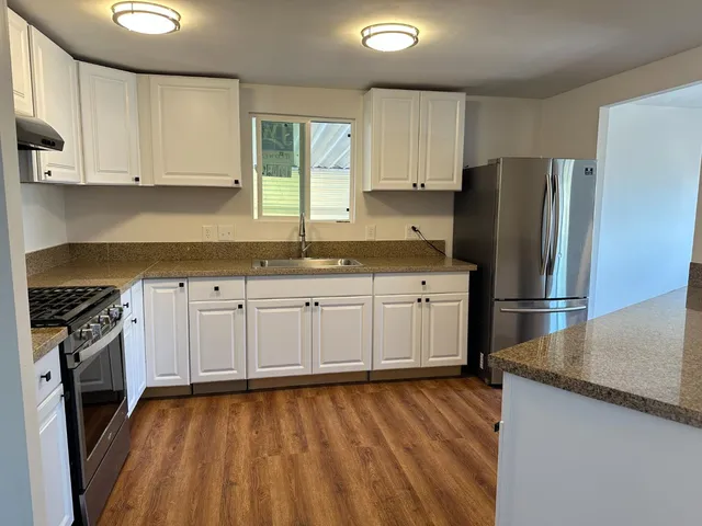 a kitchen with stainless steel appliances a stove a sink and a refrigerator