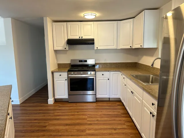 a view of a kitchen with wooden floor and electronic appliances