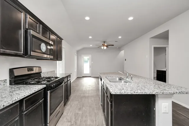 a kitchen with a sink and wooden floor