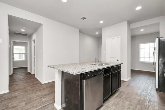 a view of a kitchen with a sink stove and wooden floor