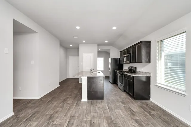 a kitchen with stainless steel appliances granite countertop a sink stove and refrigerator