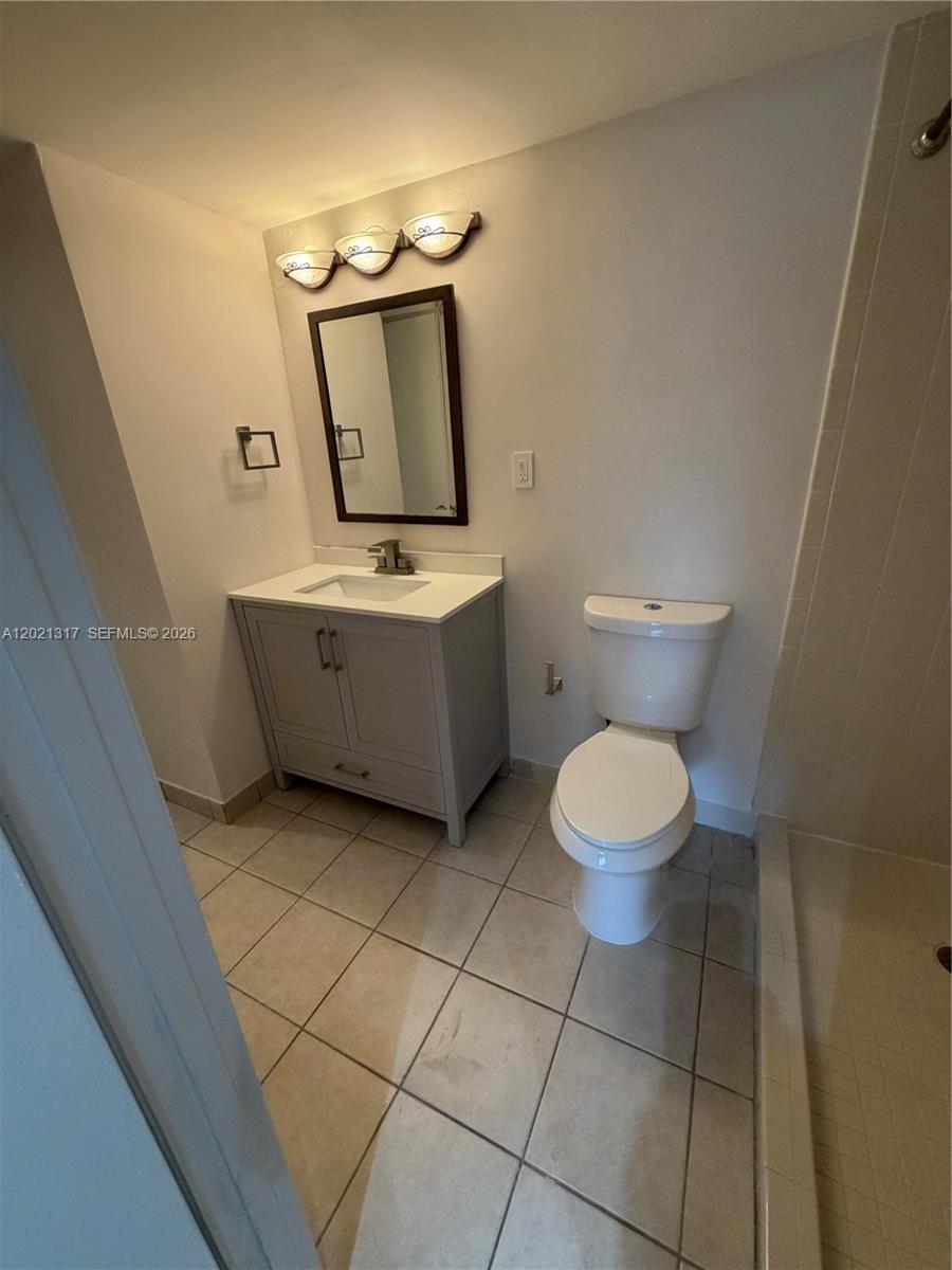 11201 Southwest 88th Street, Unit 102A Miami, FL 33173 - Photo 8 of 12 a bathroom with a toilet sink and mirror