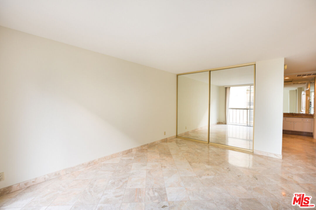 10747 Wilshire Boulevard, Unit 905 Los Angeles, CA 90024 - Photo 4 of 7 an empty room with cabinet and mirrors