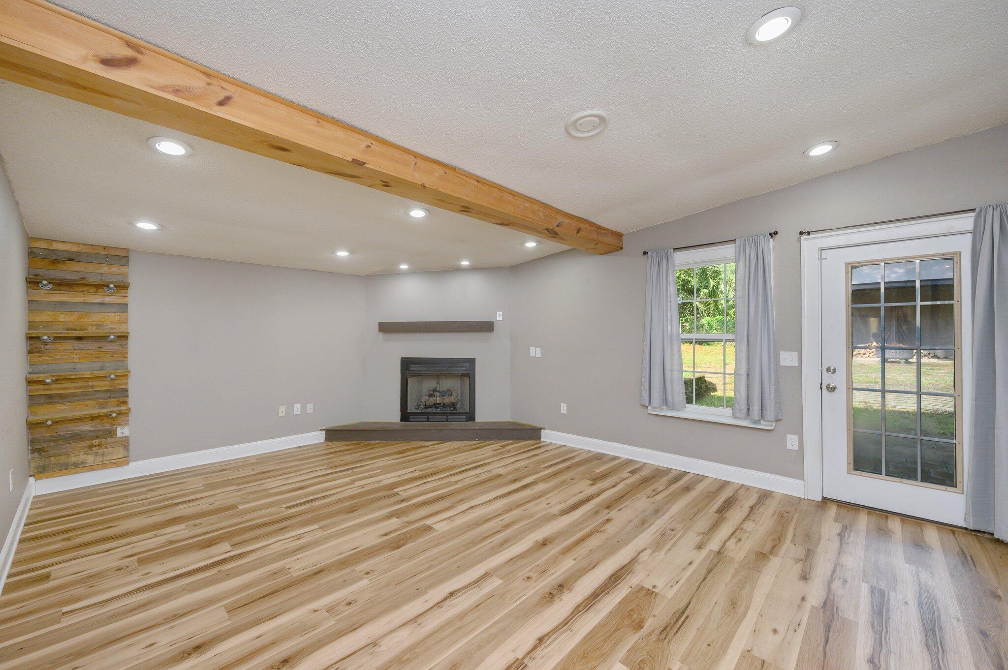 111 Sikes Drive Crestview, FL 32539 - Photo 2 of 46 a view of an empty room with a window and wooden floor