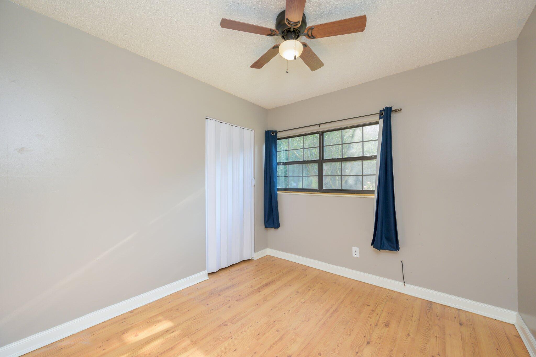 111 Sikes Drive Crestview, FL 32539 - Photo 25 of 46 an empty room with wooden floor and windows