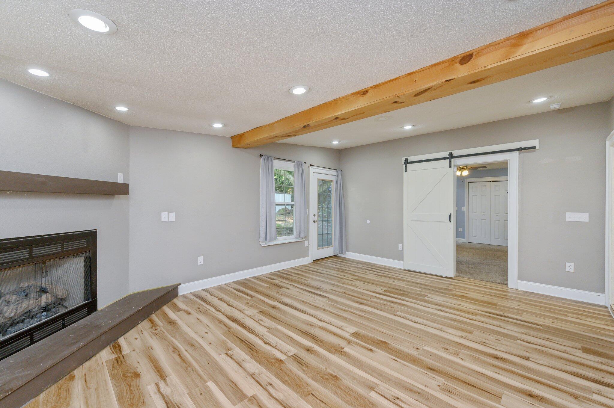 111 Sikes Drive Crestview, FL 32539 - Photo 5 of 46 a view of empty room with wooden floor and fireplace