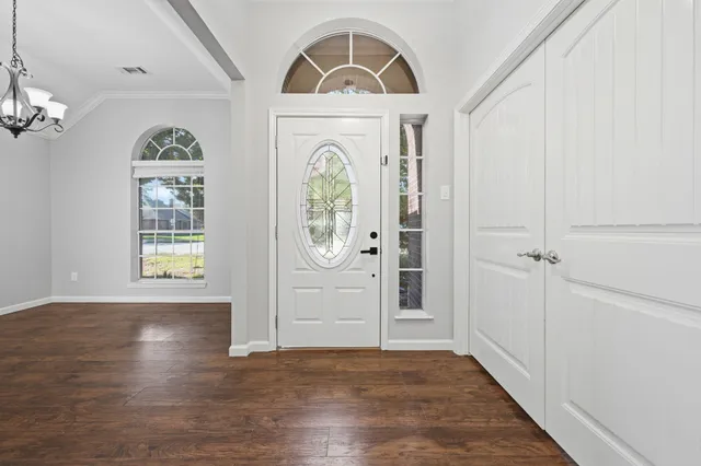 wooden floor in an entryway with a window