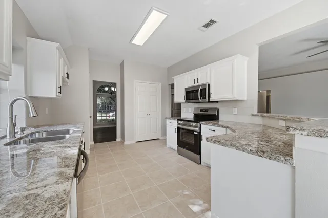 a kitchen with granite countertop a sink and steel appliances