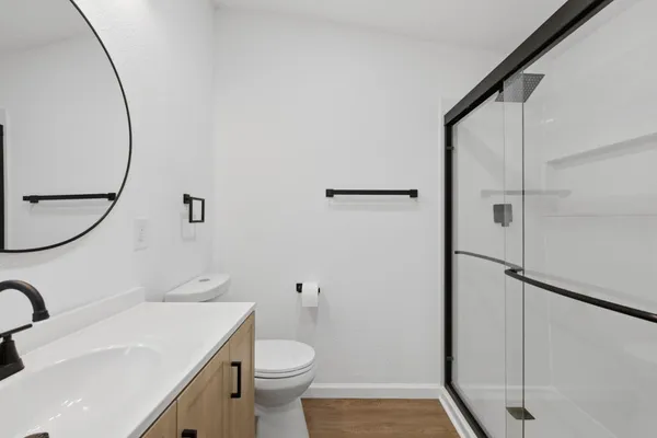 a bathroom with a sink a toilet and shower