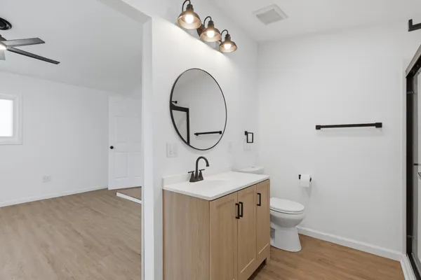 a bathroom with a sink a toilet and a mirror