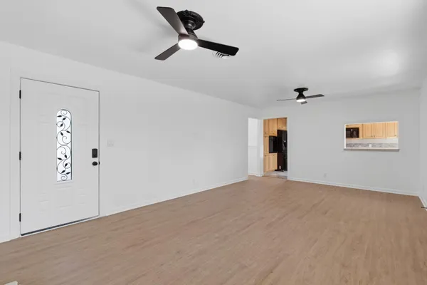 an empty room with windows and fan